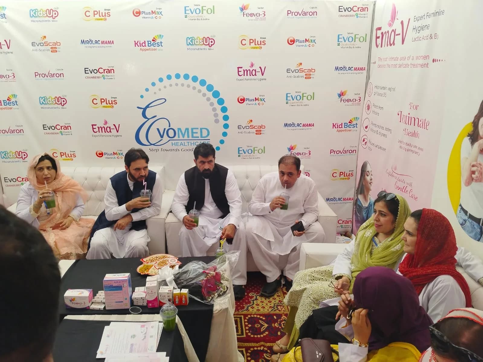 Guests seated in front of the Evomed backdrop at the conference