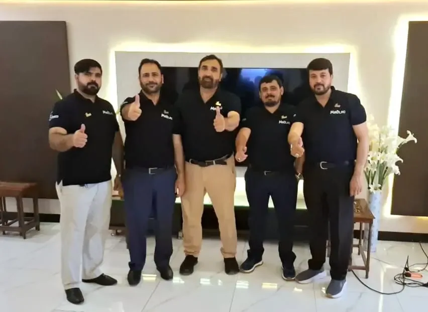 Four team members giving a thumbs up